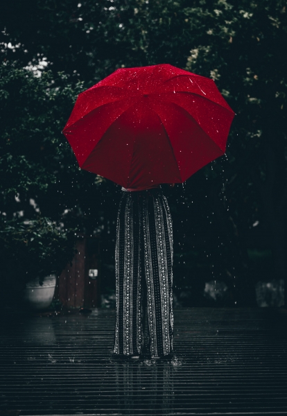 雨の中、傘をかけた女